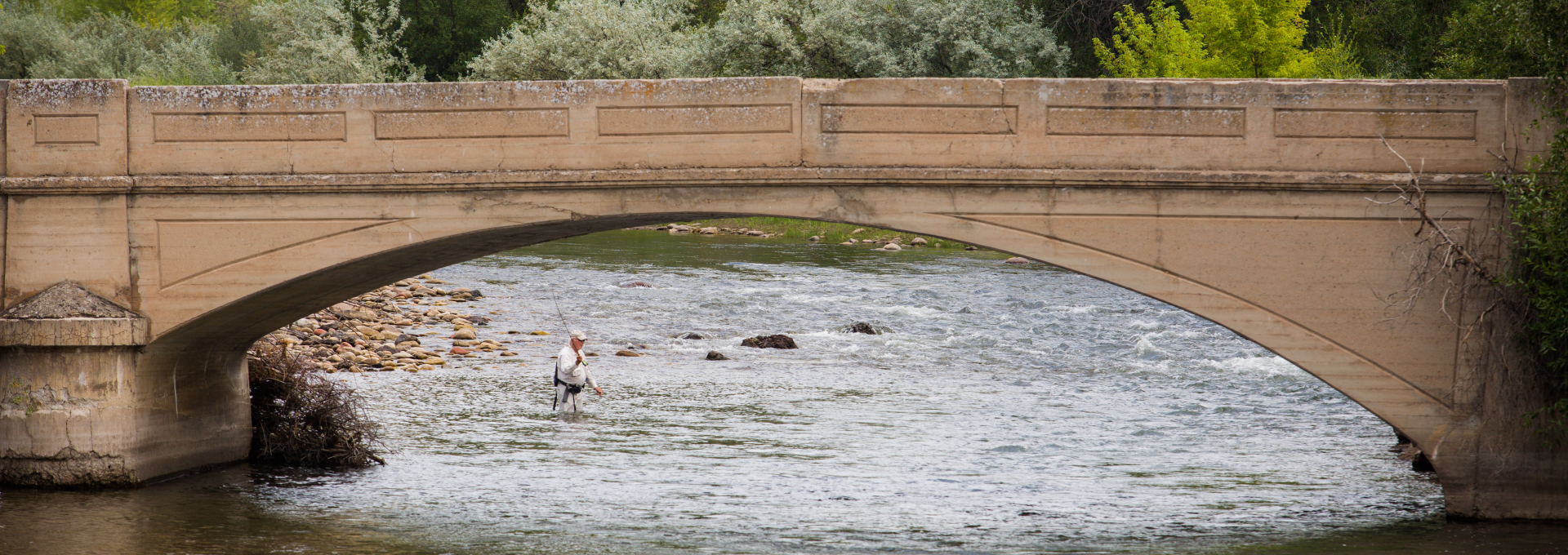 Person fishing under a bridge