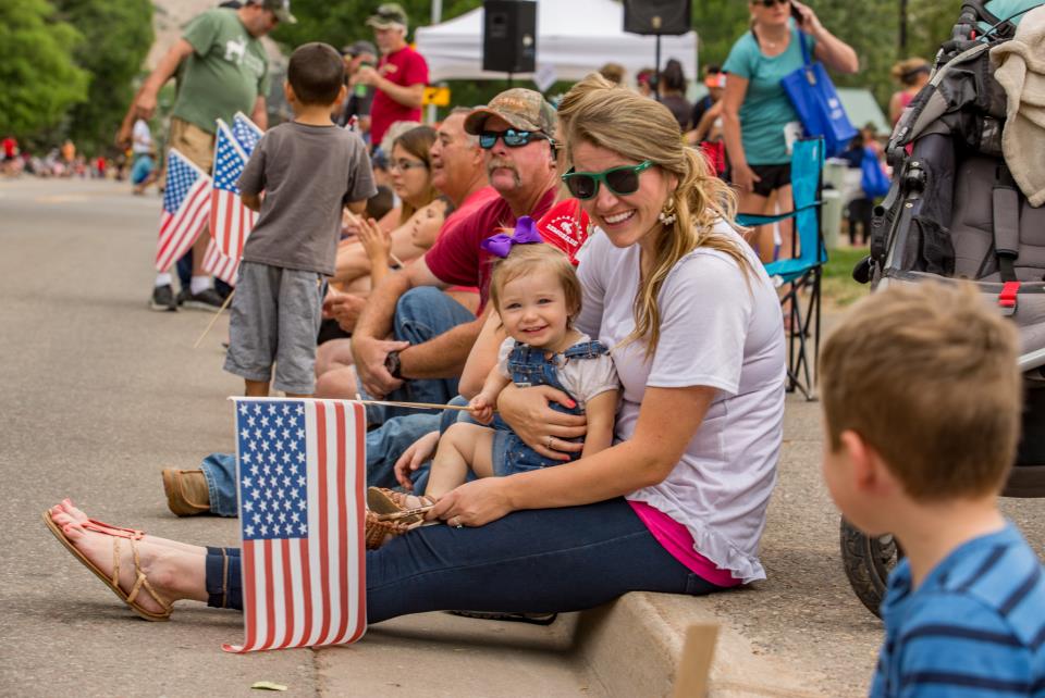 families sitting on the curb waiting for the 4th of july parade