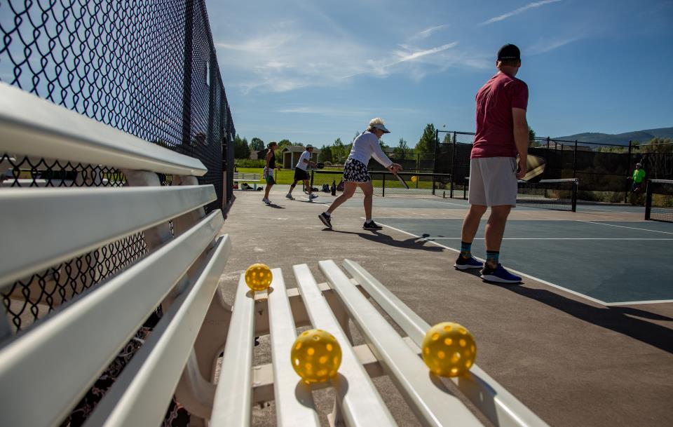 view from pickle ball bench of people playing pickleball on the pickleball courts