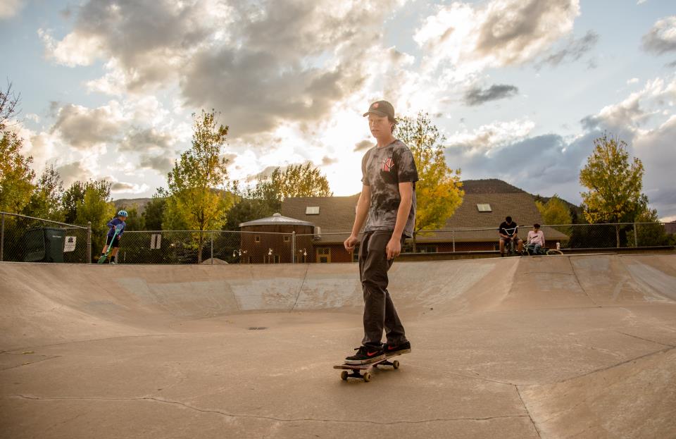 kid riding a skate board in the bowl at Gypsum Skate Park